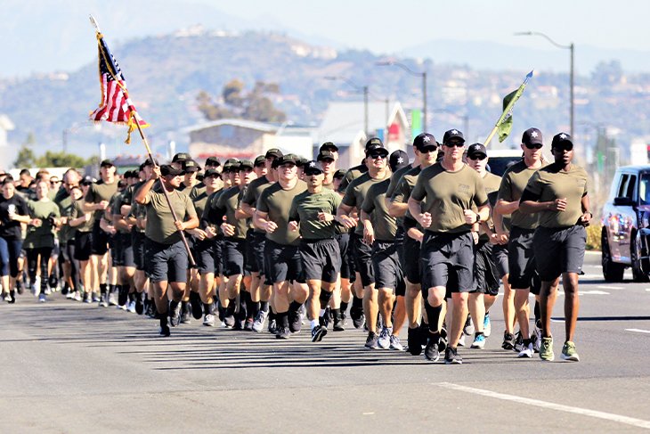 Recruits running in formation with flags
