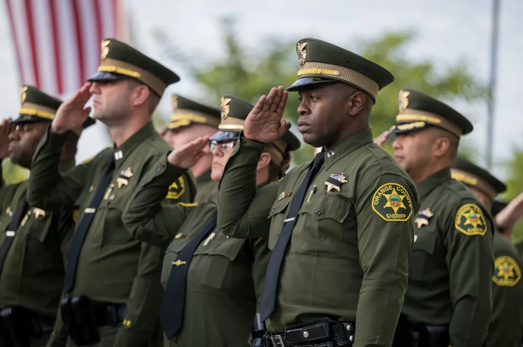 Orange County Sheriff deputies in dress uniform saluting at the 2026 Peace Officers’ Memorial ceremony