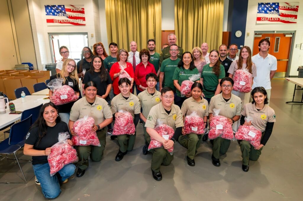 Sheriff's Explorers and volunteers holding bags of red ribbons